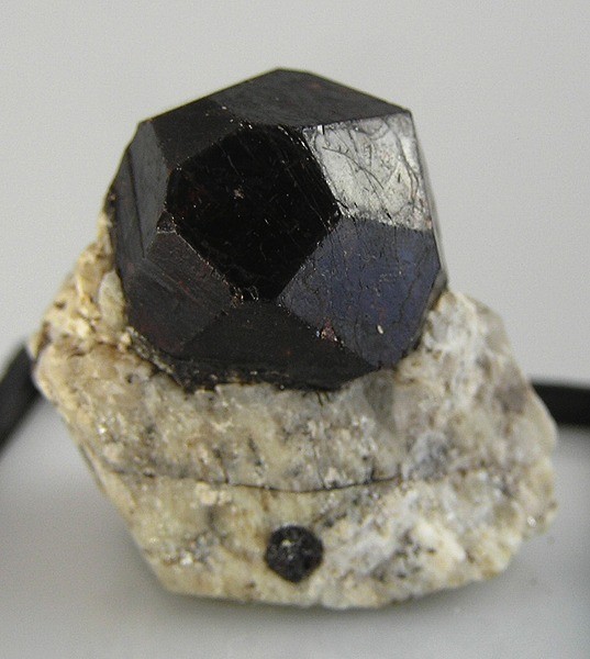 Sharp geometric Almandine crystal perched on volcanic matrix